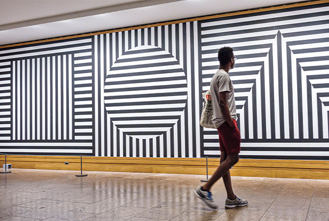 Enlargeable image of a person observing black & white geometric line art pieces