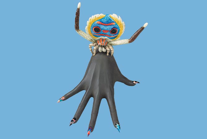 Enlargeable image of sculpted hand with a colorful spider attached to it