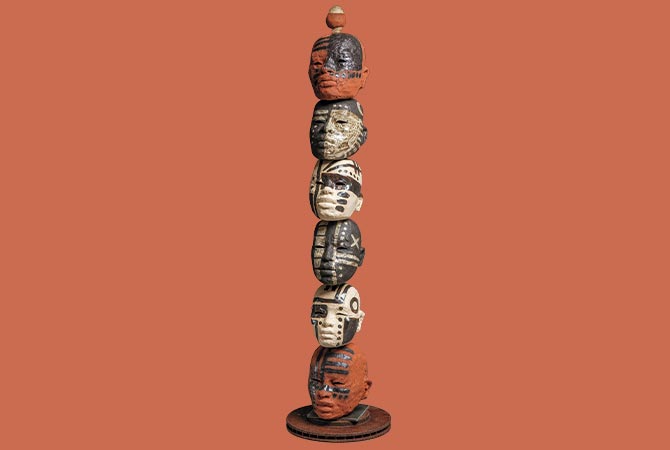 Enlargeable image of small heads stacked on top of each other to form a tower