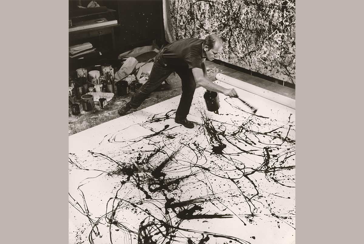 Image of Pollock creating one of his famous paintings