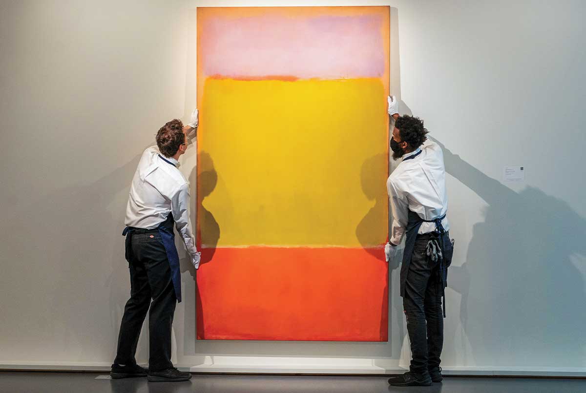 Image of two people hanging up a Rothko painting