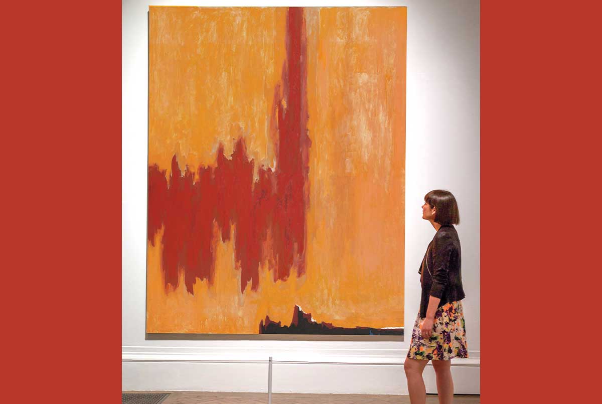 Image of a person viewing a red and orange painting