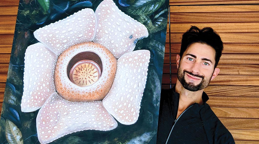 Image of a painter holding up their painting of a large flower